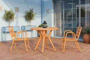 Juego de comedor para exterior con mesa redonda y cuatro sillas en color terracota. Ubicado en un patio con piso de loseta, macetas decorativas, plantas y puertas corredizas de vidrio, creando un ambiente acogedor y contemporáneo.