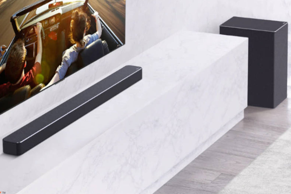 Barra de sonido negra y subwoofer sobre fondo blanco