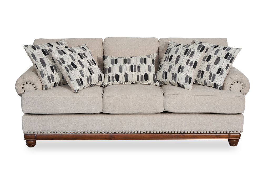 Sofá beige con cojines estampados sobre fondo blanco.