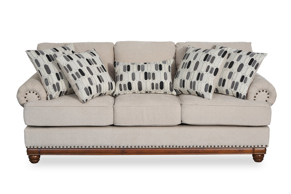 Sofá beige con cojines estampados sobre fondo blanco.