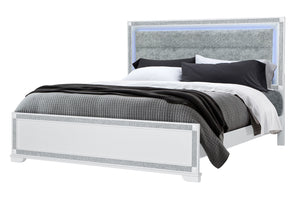 Cama con ropa de cama gris y marco blanco sobre fondo blanco.