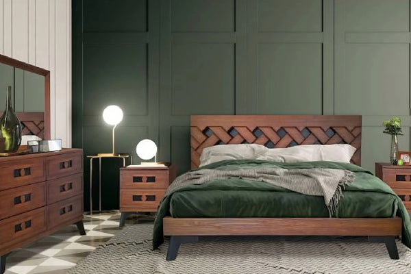 Juego de cuarto hecho de madera marrón que incluye una cama, dos mesas de noche y un gavetero con espejo en una habitación con paredes verdes. 