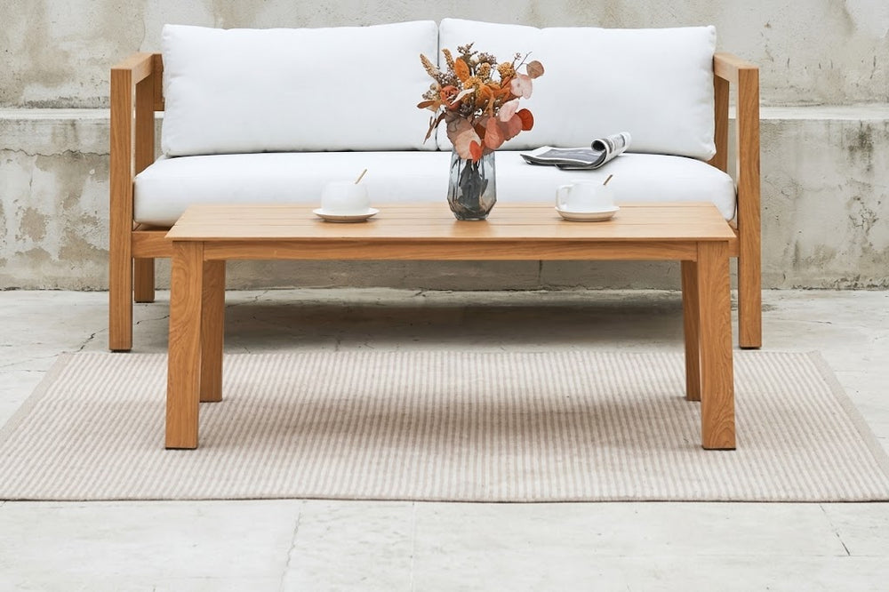 Mesa de centro de madera con elementos decorativos en un ambiente de sala de estar.