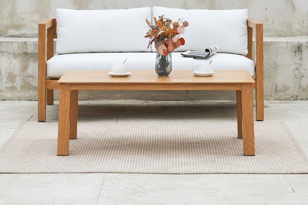 Mesa de centro de madera con elementos decorativos en un ambiente de sala de estar.