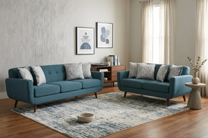 Sala de estar moderna con sofá y loveseat azules, una alfombra y objetos decorativos.