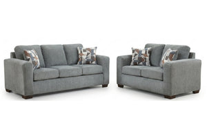 Sofá y loveseat grises con cojines estampados sobre un fondo blanco.