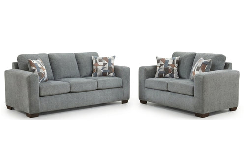 Sofá y loveseat grises con cojines estampados sobre un fondo blanco.