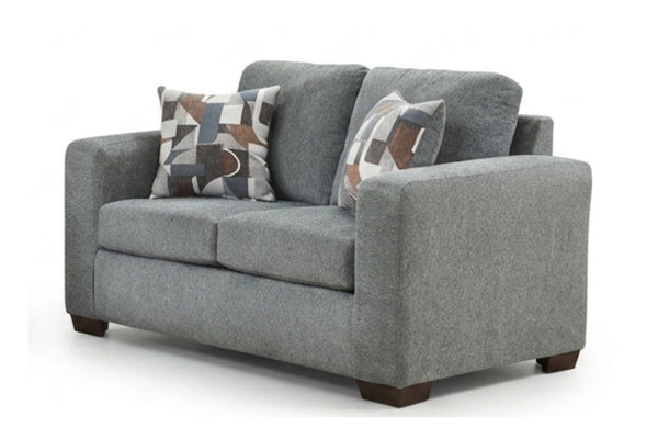Loveseat gris con cojines estampados sobre fondo blanco.