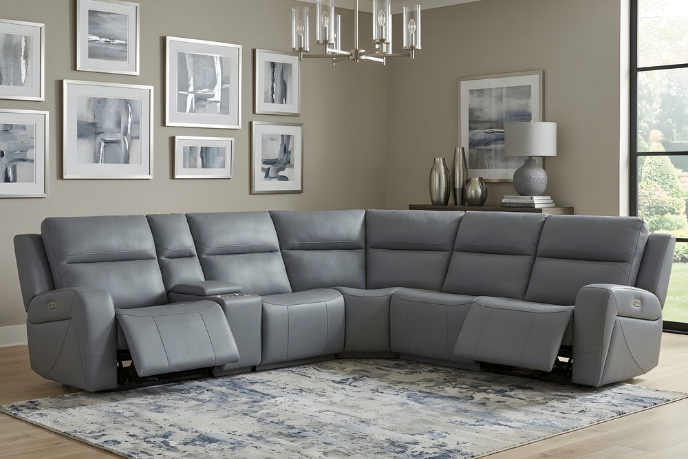 Sofá seccional reclinable gris, de diseño curvo, con respaldos acolchados, brazos laterales anchos, consola central con portavasos y controles eléctricos en los extremos sobre un fondo blanco.