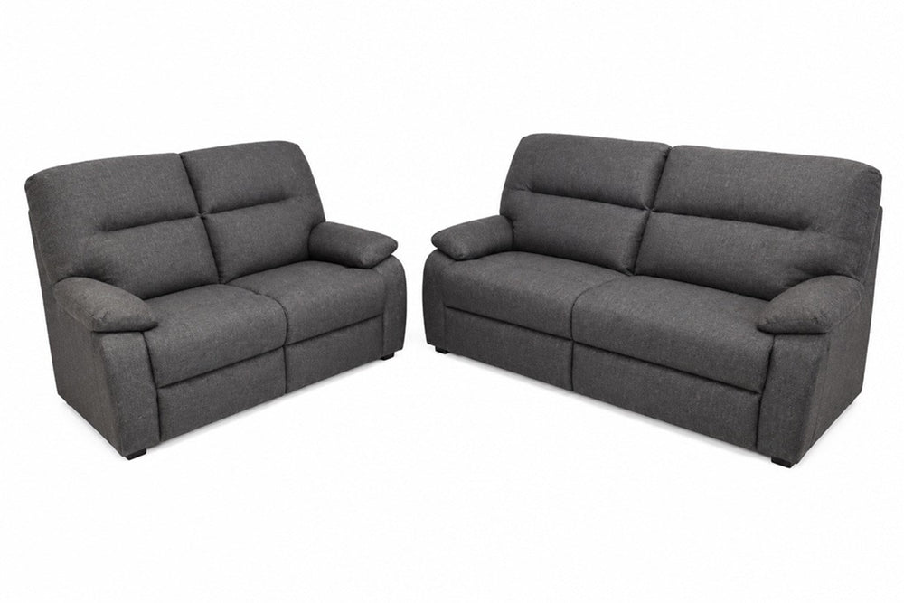 Un sofá biplaza reclinable de tela gris oscuro y un loveseat reclinable a juego, mostrados sobre un fondo blanco liso.