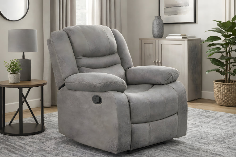 Butaca reclinable gris tapizada en tela, con respaldo alto acolchado, brazos tipo almohada, asiento amplio, botón lateral de reclinación y base reclinable visible sobre un fondo blanco.