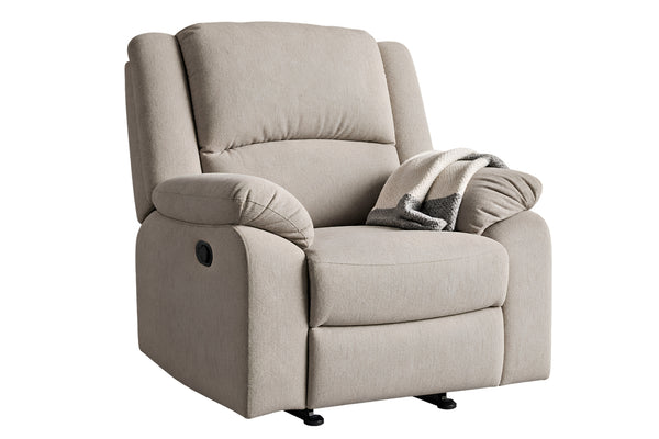 Una butaca reclinable tapizada en color beige claro, con un cojín decorativo a juego y una manta de punto gris doblada, sobre un fondo blanco liso.