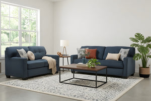Sofá y loveseat de color azul oscuro con cojines en una habitación moderna con mesa de centro. 