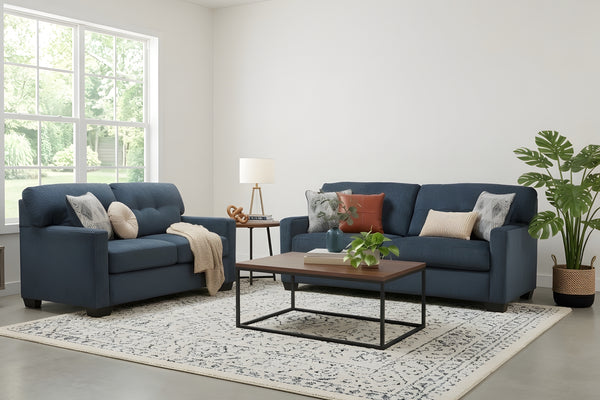 Sofá y loveseat de color azul oscuro con cojines en una habitación moderna con mesa de centro. 