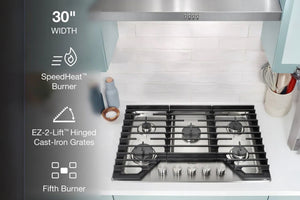 Tope de cocina a gas de acero inoxidable con características resaltadas sobre una encimera de cocina.