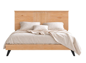 Cama de plataforma moderna con cabecera y pie de cama a juego en madera natural clara, decorada con ropa de cama y almohadas en color beige, sobre un fondo blanco.