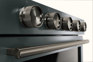 Primer plano del frente de un horno o estufa moderno con cinco perillas de control metálicas y un mango horizontal largo, mostrado sobre un fondo blanco limpio.
