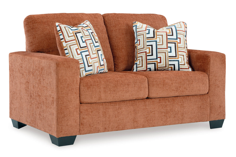 Loveseat de color anaranjado con cojines sobre un fondo blanco. 