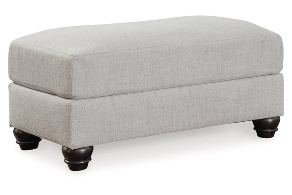 Ottoman rectangular de color gris con patas negras sobre un fondo blanco. 