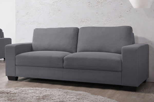 Sofá de color gris en una sala neutral. 