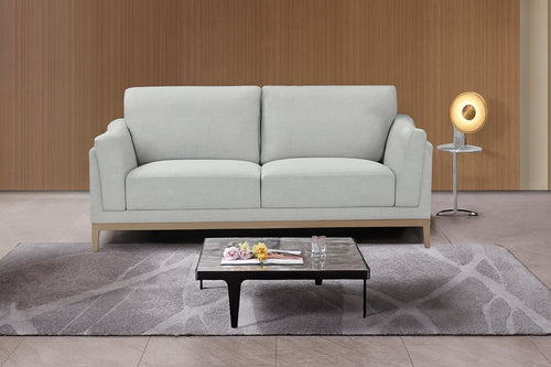 Sofá gris claro en ambiente de sala de estar con mesa de centro y elementos decorativos.