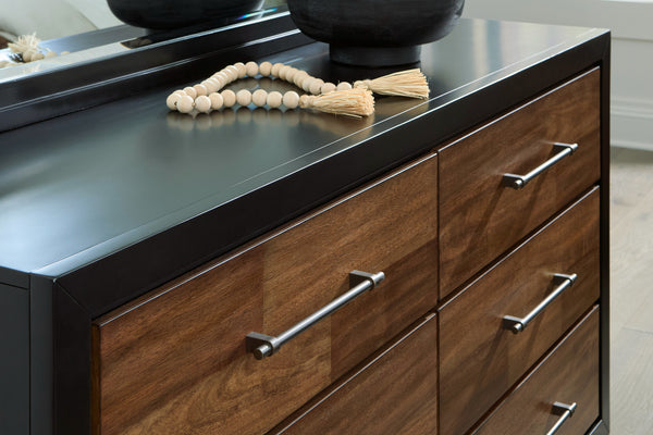 Gavetero de madera con tiradores metálicos sobre suelo de color claro.