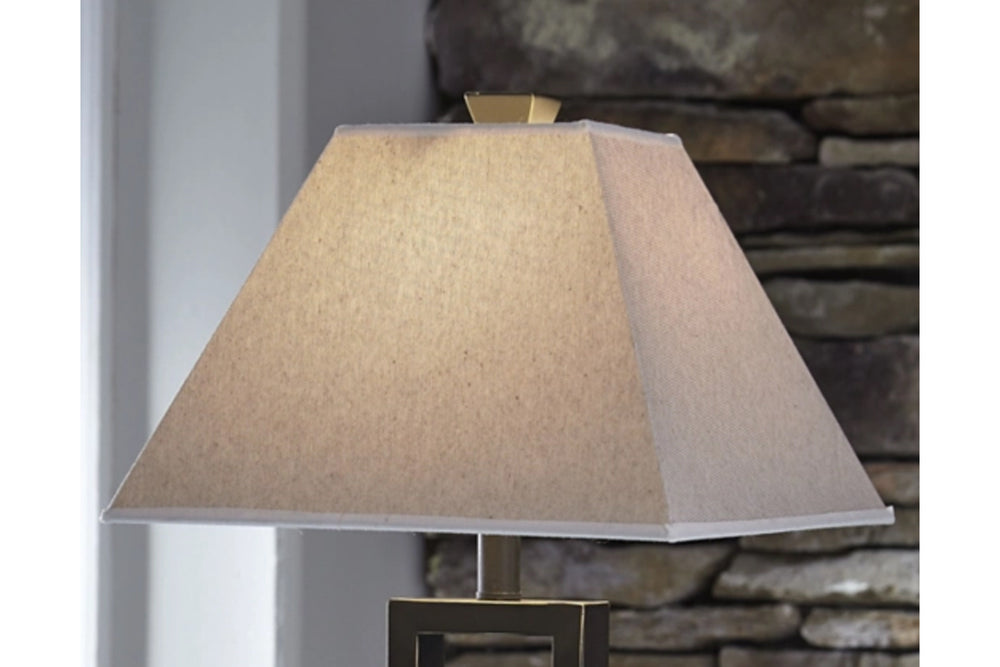 Lámpara de sobremesa con pantalla beige sobre fondo blanco.