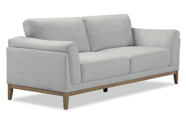 Loveseat gris con patas de madera sobre fondo blanco.