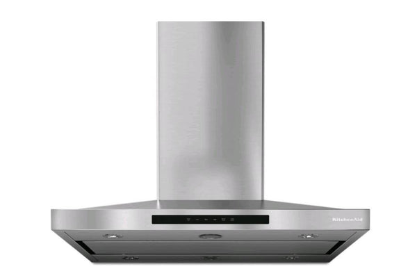 Campana extractora KitchenAid de pared en acero inoxidable con diseño tipo chimenea, iluminación LED integrada y controles electrónicos frontales. Ideal para eliminar humo, olores y vapores en cocinas modernas.