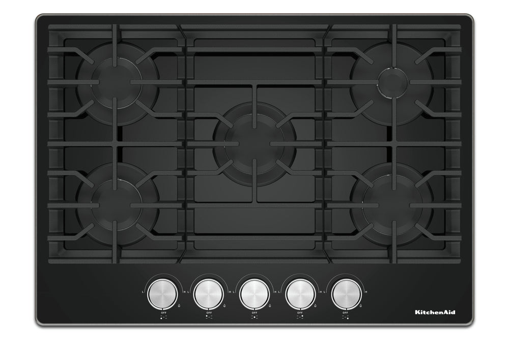 Un tope de cocción de gas KitchenAid negra con cinco perillas de control plateadas a lo largo del borde inferior, mostrada desde una perspectiva superior sobre un fondo blanco.