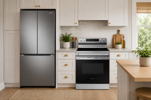 En una cocina luminosa y moderna con armarios blancos y encimeras de madera, se muestra una nevera de acero inoxidable con puertas francesas y una cocina de gas a juego con puerta de horno negra.
