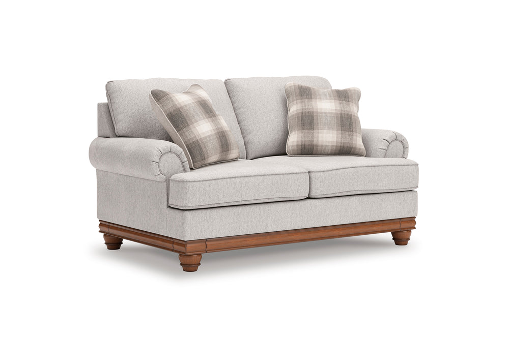 Loveseat gris claro con patas de madera y cojines a cuadros sobre fondo blanco.