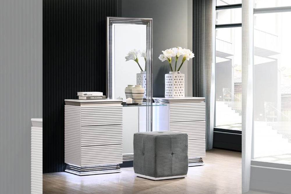 Mesa de habitación de color blanco y  con taburete pequeño plateado y con objetos decorativos en una habitación moderna. 