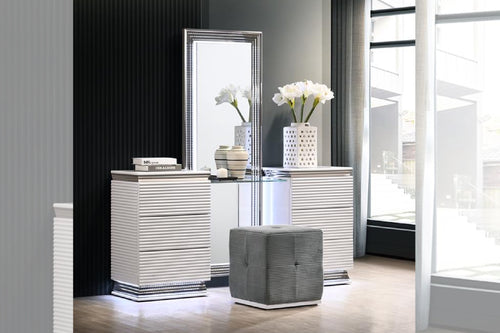 Mesa de habitación de color blanco y  con taburete pequeño plateado y con objetos decorativos en una habitación moderna. 