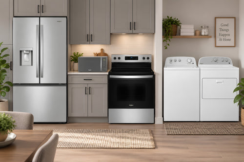 Una moderna cocina y zona de lavandería con nevera de doble puerta de acero inoxidable, estufa eléctrica a juego y lavadora y secadora de gas blancas, todo ello en un interior luminoso y contemporáneo.
