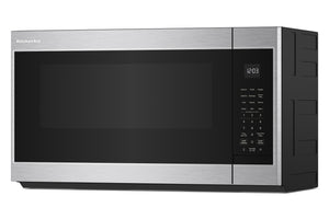 Un horno microondas KitchenAid para instalar sobre la encimera, con exterior de acero inoxidable y puerta de cristal negro, mostrado desde un ángulo de tres cuartos sobre un fondo blanco.
