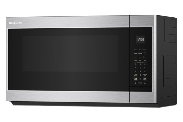 Un horno microondas KitchenAid para instalar sobre la encimera, con exterior de acero inoxidable y puerta de cristal negro, mostrado desde un ángulo de tres cuartos sobre un fondo blanco.