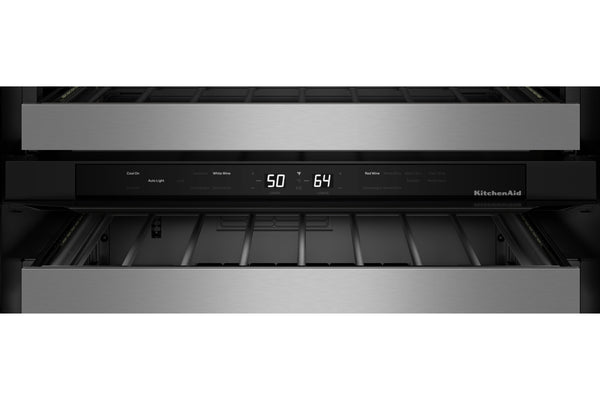 Primer plano del panel de control de una nevera de vino empotrable KitchenAid con frontal de acero inoxidable, tira de control negra, pantalla digital que muestra 50 y 64.