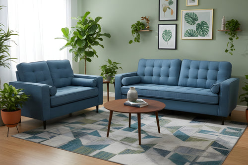 Sofá y loveseat de color azul en una sala neutral con plantas decorativas. 
