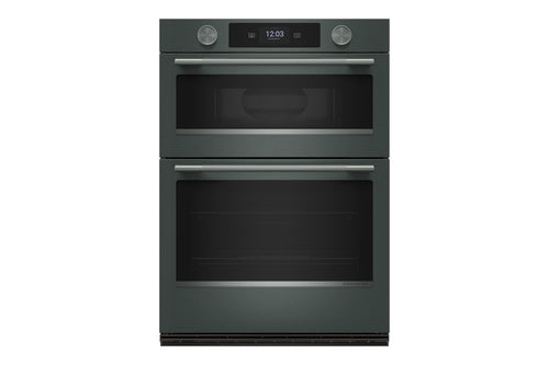 Un horno doble empotrado con acabado en verde y puertas de cristal negro, que cuenta con una pantalla de control digital y dos perillas plateadas en el panel superior, mostrado sobre un fondo blanco liso.