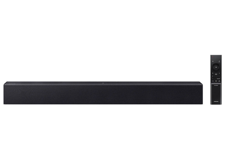 Barra de sonido negra con control remoto sobre fondo blanco. 