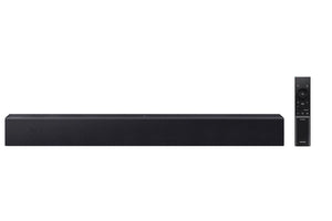 Barra de sonido negra con control remoto sobre fondo blanco. 