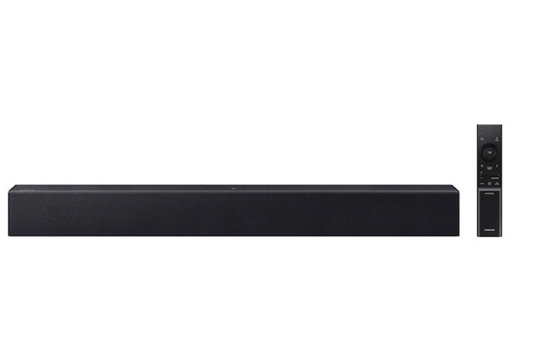 Barra de sonido negra con control remoto sobre fondo blanco. 