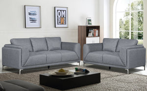 Sofá y loveseat de color gris en una sala con elementos decorativos. 