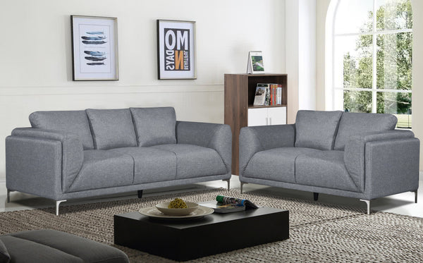 Sofá y loveseat de color gris en una sala con elementos decorativos. 