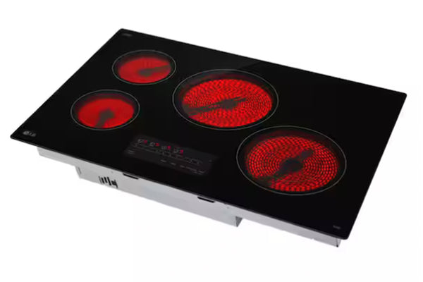 Tope de estufa negra de marca LG con cuatro quemadores prendidas sobre un fondo blanco. 