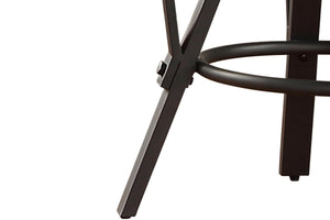 Primer plano de una pata de silla de metal negro sobre un fondo blanco.