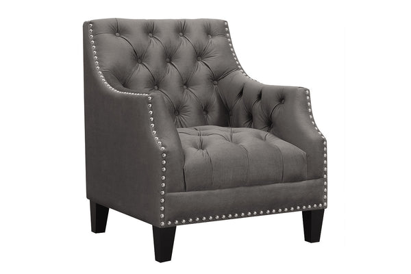 Silla de acento gris capitoné con detalles de tachuelas sobre fondo blanco.