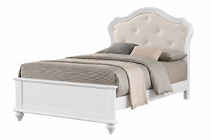 Una estructura de cama de madera blanca con cabecero tapizado en color crema y acabado capitoné, vestida con ropa de cama en tonos neutros beige y gris sobre un fondo blanco liso.