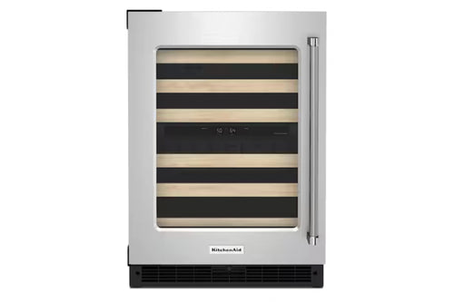 Una nevera para vinos KitchenAid bajo encimera con exterior de acero inoxidable, tirador vertical y puerta de cristal que deja ver listones de madera horizontales y negros en el interior.